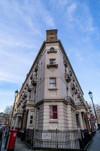 a large white building with a tower on a street at Belvedere House (Gloucester Road) in London