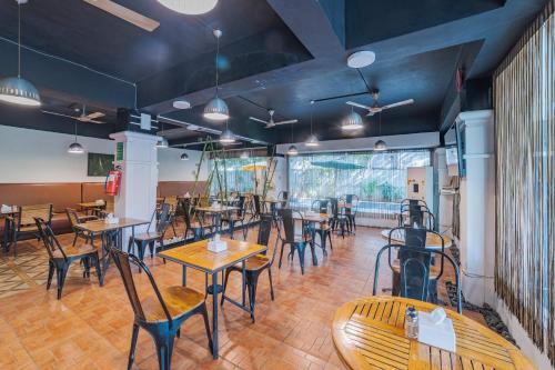 a restaurant with tables and chairs in a room at Hotel Athome & Serviced Apartments by Deccan Serai Hotels in Hyderabad