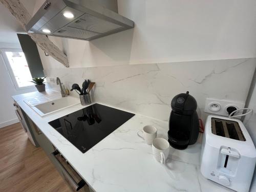eine Küche mit einer weißen Arbeitsplatte und einem Waschbecken in der Unterkunft LOFT COSY - CENTRE HISTORIQUE climatisé in Revel