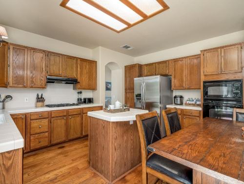 a kitchen with wooden cabinets and a wooden table with a wooden table sidx sidx sidx at Home oasis with sauna, jacuzzi, pool & heated gazebo! in Clovis