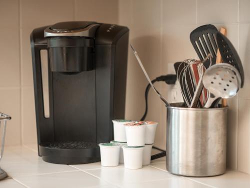 a coffee maker sitting on a counter with cups at Home oasis with sauna, jacuzzi, pool & heated gazebo! in Clovis