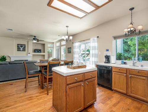 a kitchen with wooden cabinets and a dining room with a table at Home oasis with sauna, jacuzzi, pool & heated gazebo! in Clovis