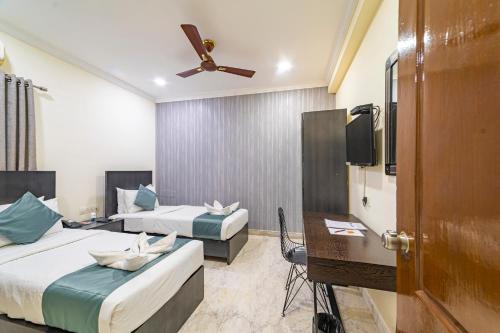a hotel room with two beds and a flat screen tv at Hotel Athome & Serviced Apartments by Deccan Serai Hotels in Hyderabad