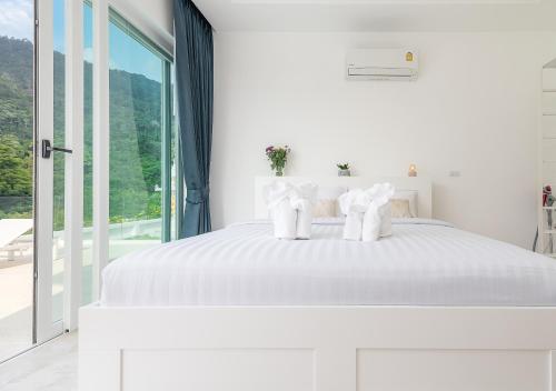 a white bedroom with a white bed and a window at Vimaan Vilai - Secluded Pool Villa in Nathon Bay