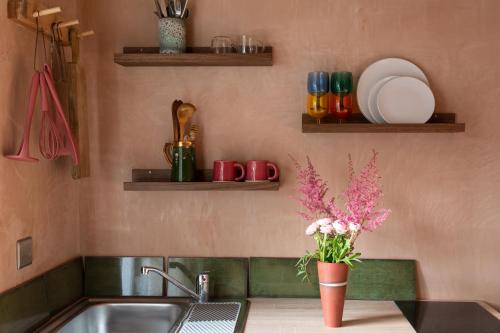 - un comptoir de cuisine avec un évier et un vase de fleurs dans l'établissement Garden Studio Annex w/free parking, à Hemel Hempstead