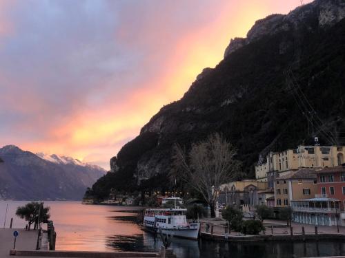 a group of boats docked on the water near a mountain at Hotel Centrale in Riva del Garda