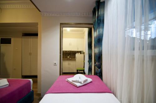 a bedroom with two beds with pink sheets and a mirror at Paris Garden Hotel Istanbul in Istanbul
