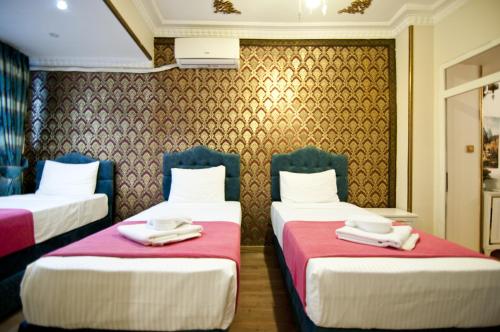 two beds in a hotel room with towels on them at Paris Garden Hotel Istanbul in Istanbul