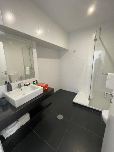 a bathroom with a sink and a shower at Colégio 86 in Ponta Delgada