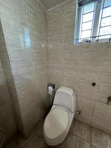 een badkamer met een wit toilet en een raam bij Private Room near Istanbul Airport 5 in Arnavutköy