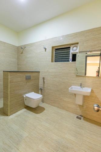 a bathroom with a sink and a toilet at TTK Residency in Āndippatti