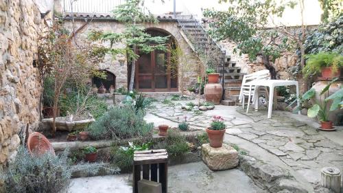 Cerviá的住宿－Cal Marquès，种植了盆栽植物的花园,石头建筑