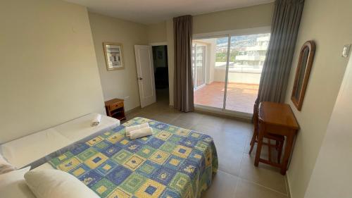 a hotel room with a bed and a balcony at benal beach 81 in Benalmádena