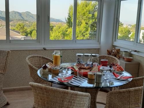 un tavolo con cibo e bevande e finestre di B&B Los Zuecos a Macisbenda