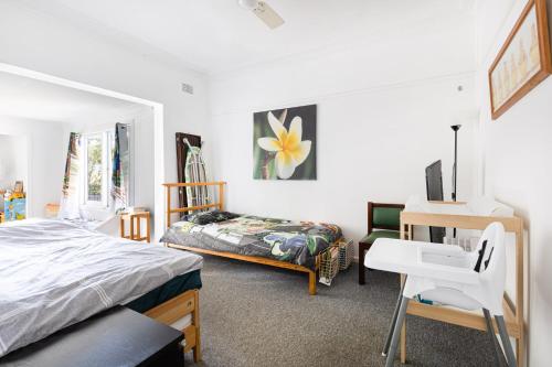 1 dormitorio con cama, escritorio y silla en Work from country side with urban amenities, en Kurmond