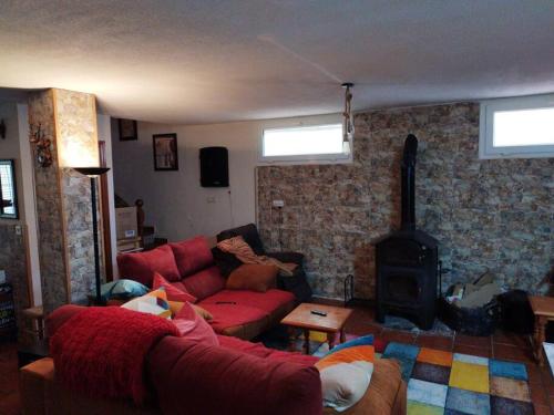 a living room with a red couch and a fireplace at La casa de Gloria in Cúllar-Vega