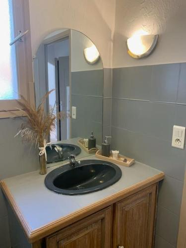 une salle de bain avec un lavabo noir et un miroir dans l'établissement Maison dans lotissement, à Villeneuve-Loubet
