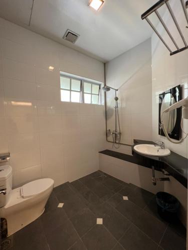 a white bathroom with a toilet and a sink at D Eastern Hotel in Ipoh