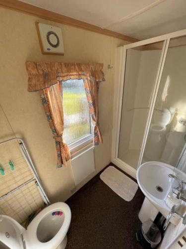 a small bathroom with a toilet and a sink at MIĘDZY NAMI domki nad jeziorem in Kołczewo