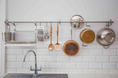 a kitchen with pots and pans hanging on a wall at Lovely Annexe by the Beach, in Central Worthing. in Broadwater