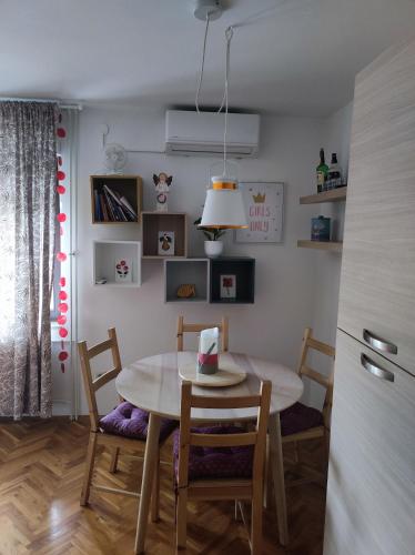 a dining room with a table and chairs and a kitchen at Apartment Blondie Zagreb in Zagreb