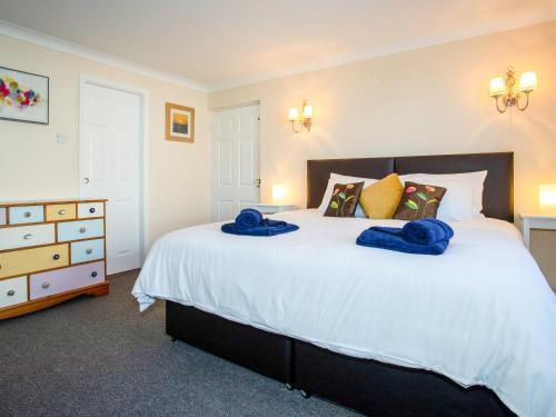 a bedroom with a large white bed with blue towels on it at Dreamcatcher in South Hayling