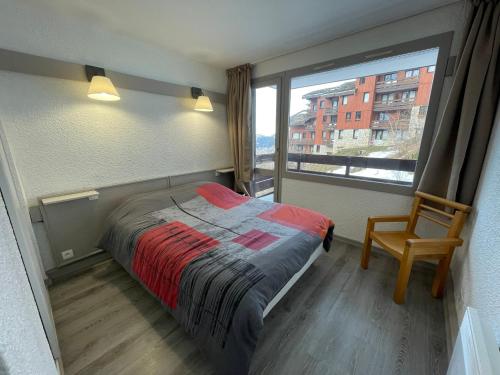 um quarto com uma cama e uma grande janela em Appartement Plagne 1800, 2 pièces, 4 personnes - FR-1-181-2708 em La Plagne Tarentaise