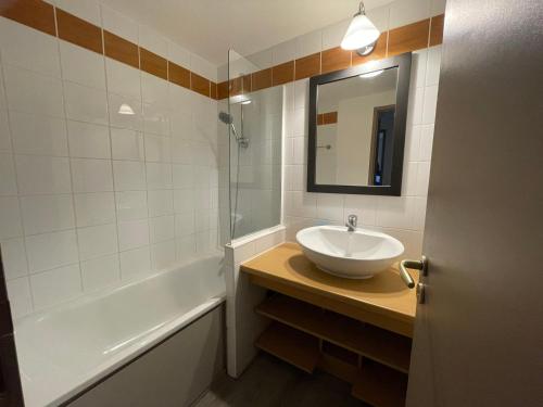 uma casa de banho com um lavatório, uma banheira e um espelho. em Appartement Plagne 1800, 2 pièces, 4 personnes - FR-1-181-2708 em La Plagne Tarentaise