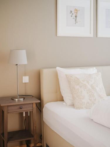 a bedroom with a bed and a table with a lamp at Appartement Meyer-Ernzen in Echternach