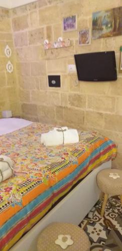 a bedroom with a bed with a laptop on the wall at Le camelie in Altamura