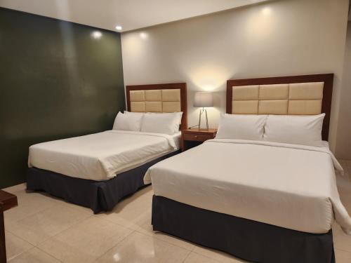 two beds in a hotel room with two beds sidx sidx sidx at Hotel Herencia 625 in Daraga
