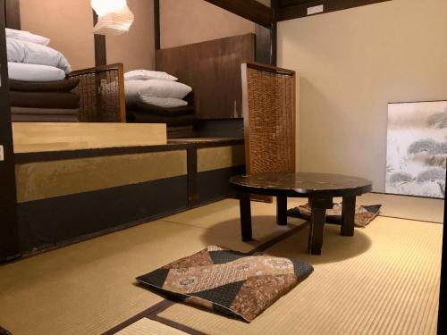 Zimmer mit einem Tisch und 2 Etagenbetten in der Unterkunft Guest House Kingyoya in Kyoto