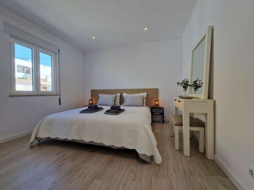 - une chambre blanche avec un grand lit et un bureau dans l'établissement Casa Liberdade - Modern townhouse with terrace roof, à Estômbar