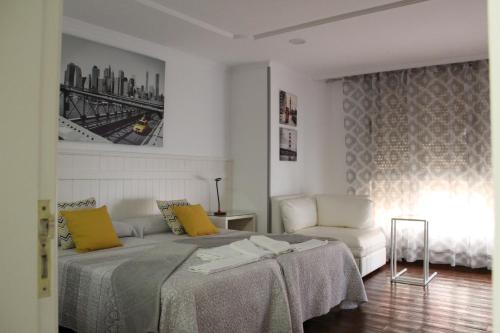 ein Schlafzimmer mit einem Bett, einem Sofa und einem Stuhl in der Unterkunft Apartamento Boutique Cruce de Melenara in Melenara
