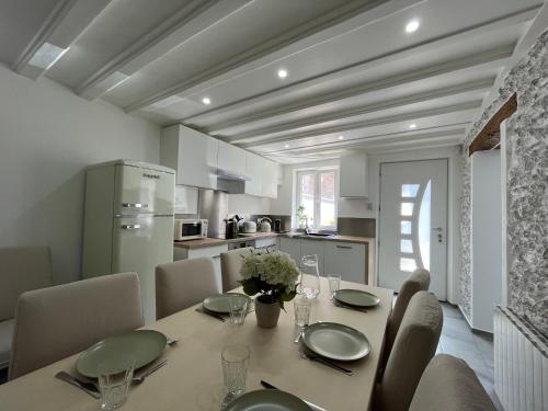 une cuisine et une salle à manger avec une table et des chaises dans l'établissement Cosy &Jolie Maison tout à coté de DisneyLand Paris, à Montry