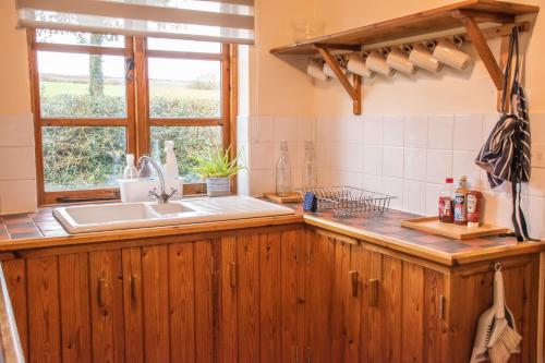 a kitchen with a sink and a window at 3-Bed Lodge with direct access to the Tarka trail in Great Torrington