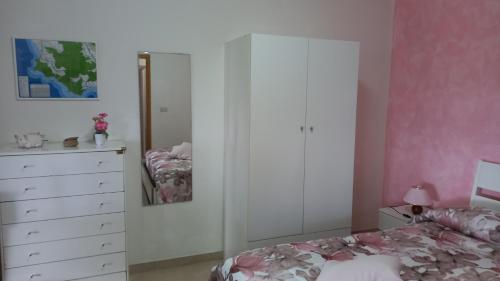 a bedroom with a white cabinet and a bed at Casa vacanze Alfano in Ascea