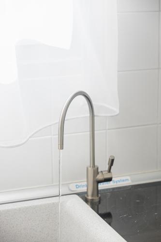 a kitchen sink with a faucet with water coming out at Alpha & Omega in Karpathos Town