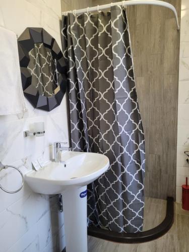 a bathroom with a sink and a shower curtain at Studio M in Plovdiv