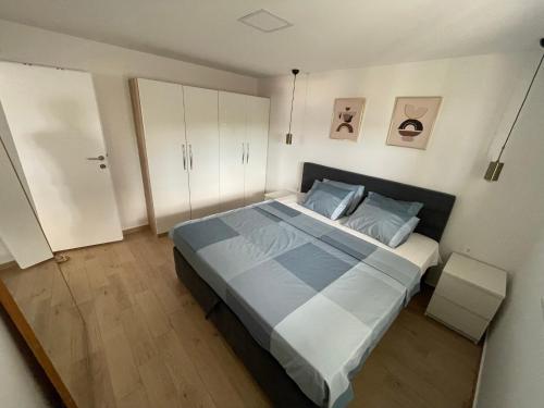 a bedroom with a large bed with blue pillows at Apartman Mate in Novigrad Dalmatia