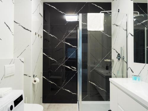 een badkamer met een douche met zwarte en witte tegels bij Szwedzka 22C Perfect Apart in Warschau