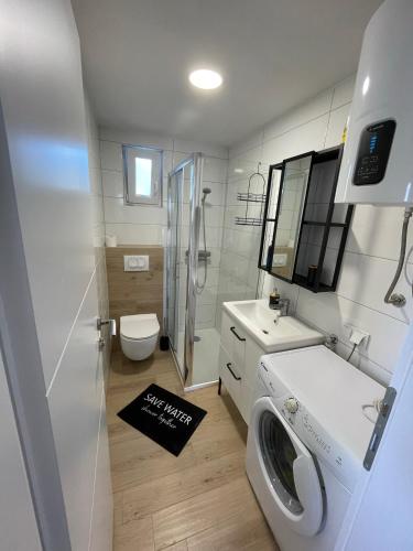 a white bathroom with a washing machine in it at Apartman Mate in Novigrad Dalmatia