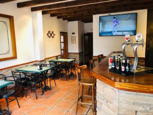 a restaurant with tables and a tv on the wall at HOSTAL JJ salduero in Salduero