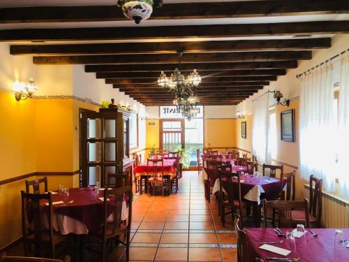 een eetkamer met tafels en stoelen in een restaurant bij HOSTAL JJ salduero in Salduero