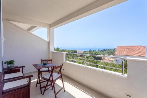 a balcony with a table and chairs and a large window at Hvar De Luxe Apartments in Hvar