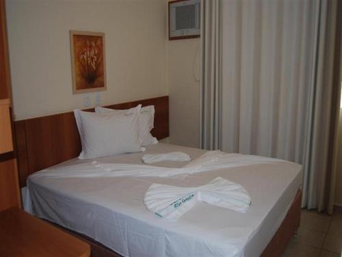 - une chambre avec un lit et 2 serviettes dans l'établissement Apartamento Serra Park, à Rio Quente