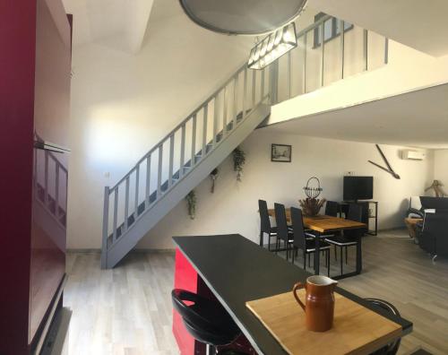 an open living room and dining room with a staircase at Gîte LE BOIS FLOTTE spacieux 120 m2 6 personnes Lagorce vallon pont d arc Ardèche in Lagorce
