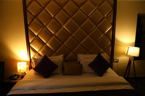 a bedroom with a large white bed with two lamps at Perfectstayz Premium Ganga Heights at Harkipauri Road in Haridwār
