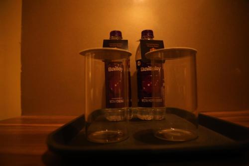 two glass vases sitting on a tray on a table at Perfectstayz Premium Ganga Heights at Harkipauri Road in Haridwār