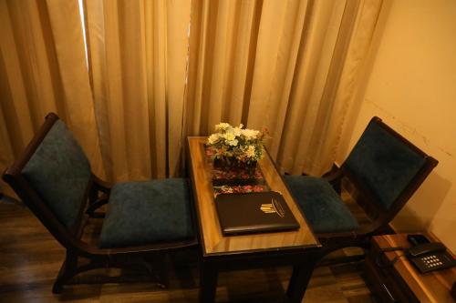 a table with two chairs and a laptop on it at Perfectstayz Premium Ganga Heights at Harkipauri Road in Haridwār